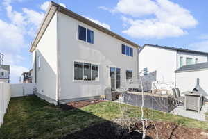 Back of house featuring stucco siding, a fenced backyard, and a gate