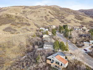Aerial view of property and surrounding area featuring nearby suburban area and mountains