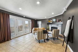 Living area featuring recessed lighting, ornamental molding, a textured ceiling, a brick fireplace, and light tile patterned flooring