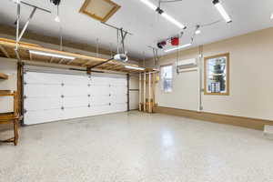 Garage featuring a mini split for heating / cooling and a garage door opener