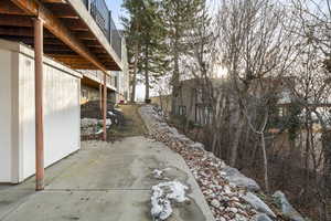 View of side of property featuring a patio and a wooden deck