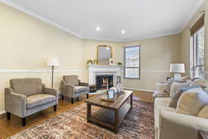 Living area with crown molding, hardwood / wood-style floors, a fireplace, and recessed lighting