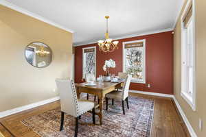 Dining space featuring a chandelier, ornamental molding, and hardwood / wood-style floors