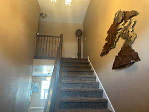 Stairway with baseboards and hanging lights