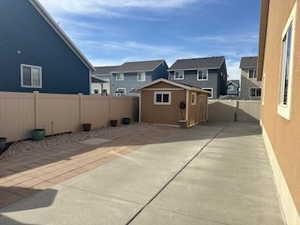Fenced backyard with a storage shed and a residential view