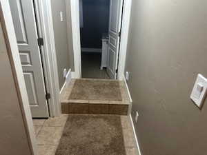 Corridor featuring baseboards and light tile patterned floors