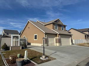 View of front of house featuring stucco siding and driveway