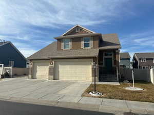Traditional home featuring concrete driveway and a garage