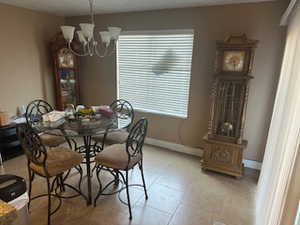 Dining area featuring a chandelier and light tile patterned flooring