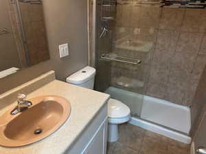 Full bath featuring vanity, a stall shower, and dark tile patterned floors