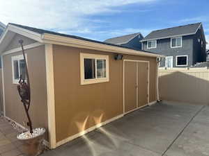 View of property exterior with an outdoor structure