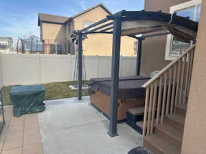 Fenced backyard with a hot tub, a patio, and a deck