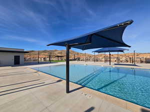 Community pool featuring a mountain view and a patio area