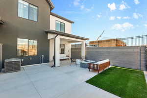 Fenced backyard with a patio area and an outdoor living space with a fire pit