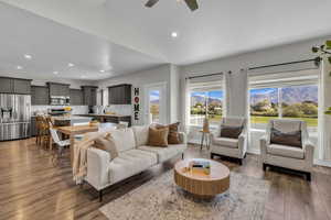 Living area with dark wood-style flooring, ceiling fan, a mountain view, recessed lighting, and vaulted ceiling