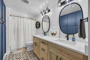 Full bath featuring a double vanity, shower / tub combo