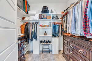 Tasteful walk-in closet, with ample custom shelving perfect for organization