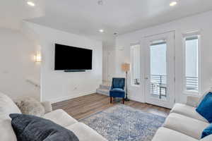 Living area with wood finished floors and recessed lighting