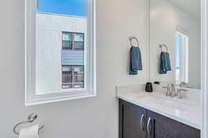 Half bath included with ample natural light, rich cabinetry, bright vanity and large mirror