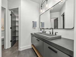 Full bathroom featuring vanity and a walk in closet