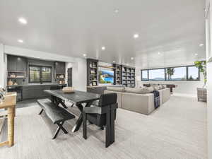 Dining space with light colored carpet, recessed lighting, and beverage cooler