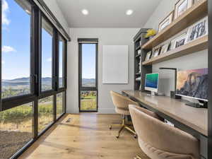 Office space with light wood finished floors, a mountain view, and recessed lighting