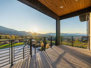 Balcony at dusk featuring a mountain view and a patio