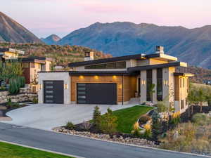 Contemporary home with a chimney, a mountain view, and concrete driveway