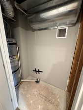 Unfinished below grade area featuring water heater