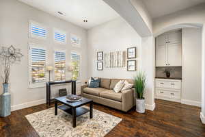 Living room featuring dark wood finished floors and a high ceiling