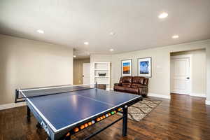 Playroom with dark wood finished floors and recessed lighting