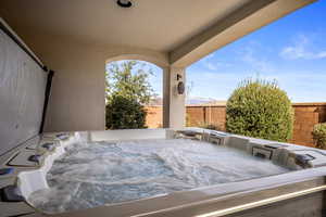 Fenced backyard with a hot tub