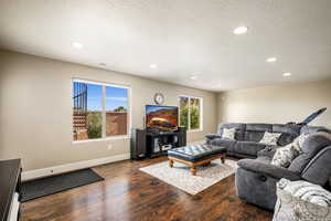 Living area featuring dark wood finished floors, recessed lighting, and a textured ceiling
