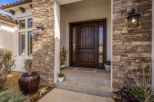 Property entrance featuring stone siding and stucco siding