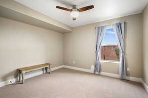 Empty room with ceiling fan and light colored carpet