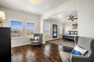 Bedroom featuring arched walkways, dark wood-type flooring, and recessed lighting