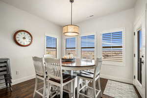 Dining area featuring healthy amount of natural light and dark wood-style floors