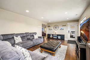 Living area featuring dark wood finished floors and recessed lighting