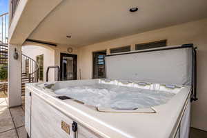 View of patio / terrace with stairway and a hot tub