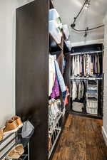 Walk in closet featuring dark wood-style flooring