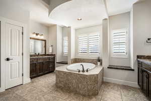 Bathroom with vanity, a garden tub, and recessed lighting