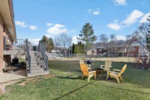 View of yard with an outdoor fire pit and a patio