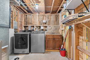 Laundry area with separate washer and dryer and unfinished concrete floors