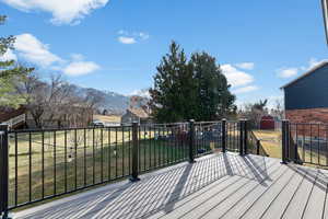 Wooden deck with a mountain view, a yard, and a shed