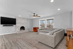 Living room featuring recessed lighting, ceiling fan, light wood-style flooring, and a brick fireplace