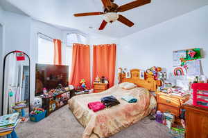 Carpeted bedroom with a textured ceiling and ceiling fan