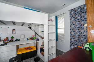 Bedroom with a textured ceiling and dark colored carpet