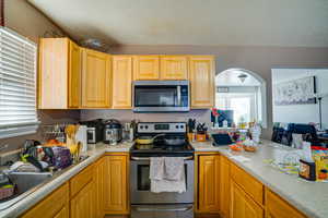 Kitchen featuring stainless steel appliances, light countertops, and a textured ceiling