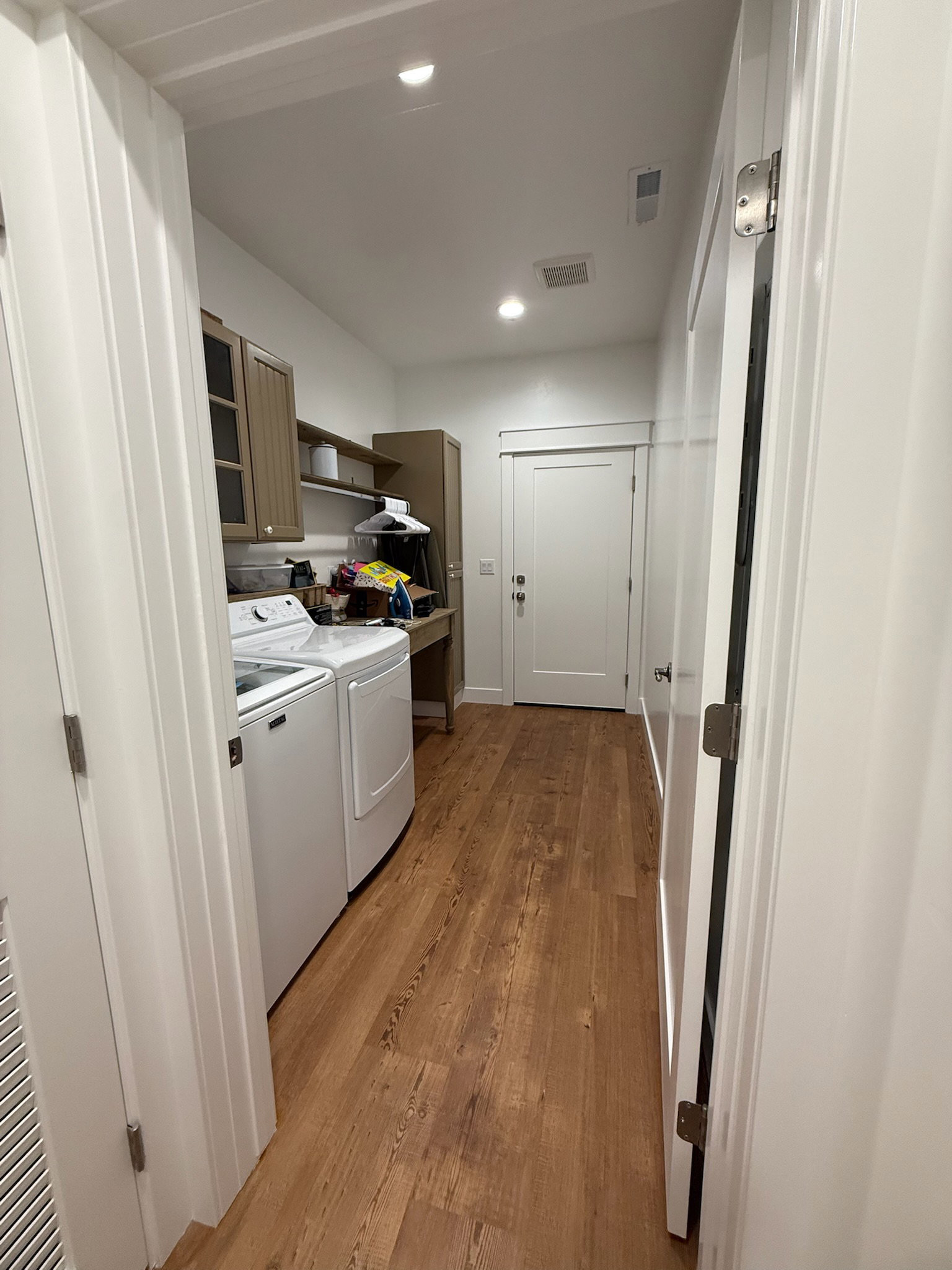 Laundry area featuring wood-finish flooring, recessed lighting, and white walls