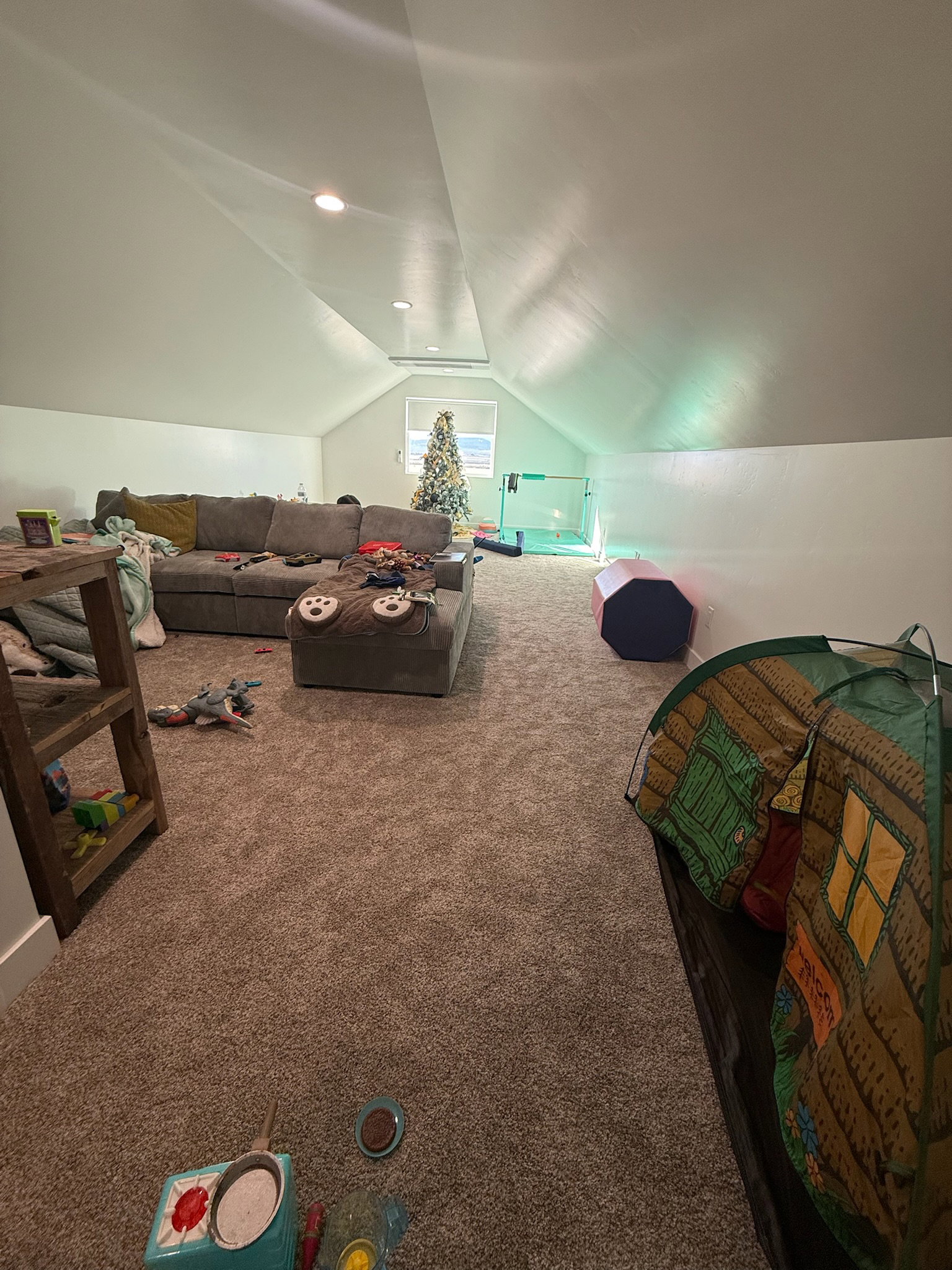 Spacious attic room featuring recessed lighting, a window providing natural light, sloped ceilings, and plush carpet flooring